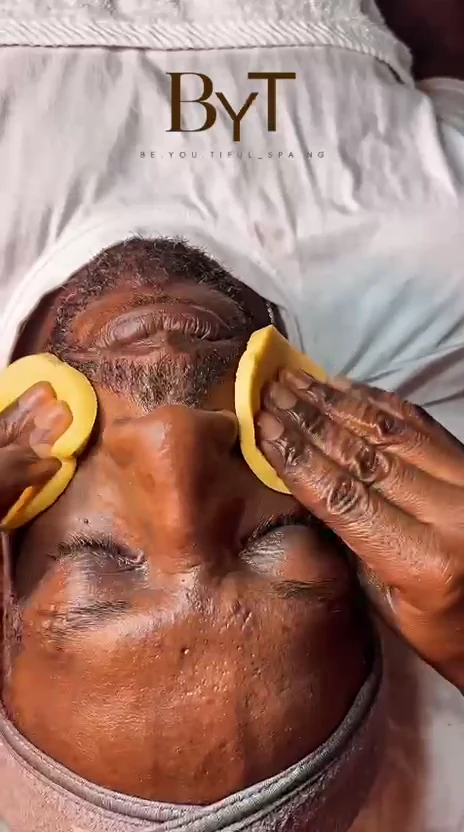 A BYT therapist's hands performing a facial